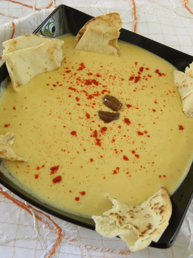 Hoummous with olives and butternut squash Hoummous in a black plate with pita chips image