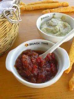 Chutney in a bowl with bread sticks image