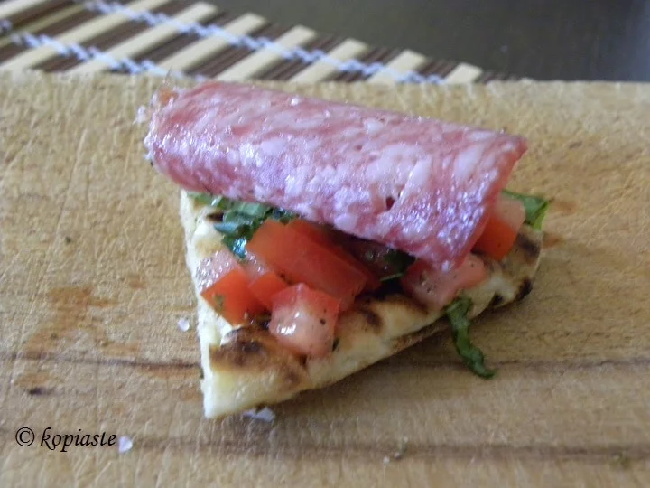 Pita chips with tomato, basil and salami