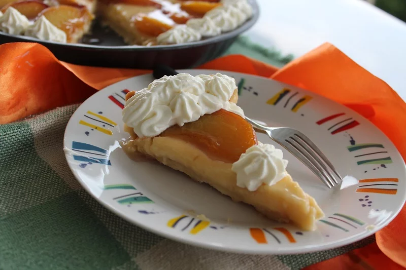 Piece of peach tarte tatin with whipped cream image