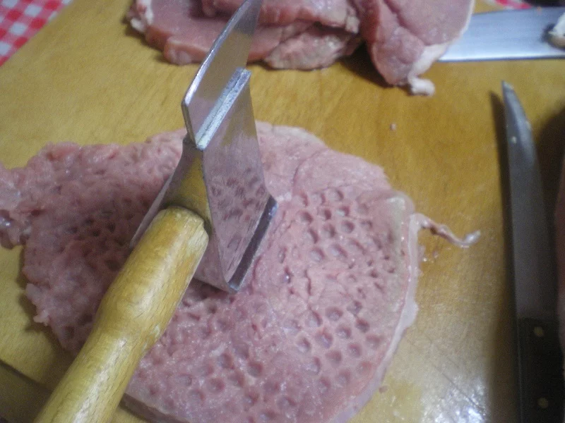 Pounding the meat with a mallet image