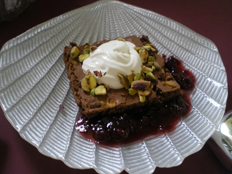 Brownies served with whipped cream and raspberry sauce image