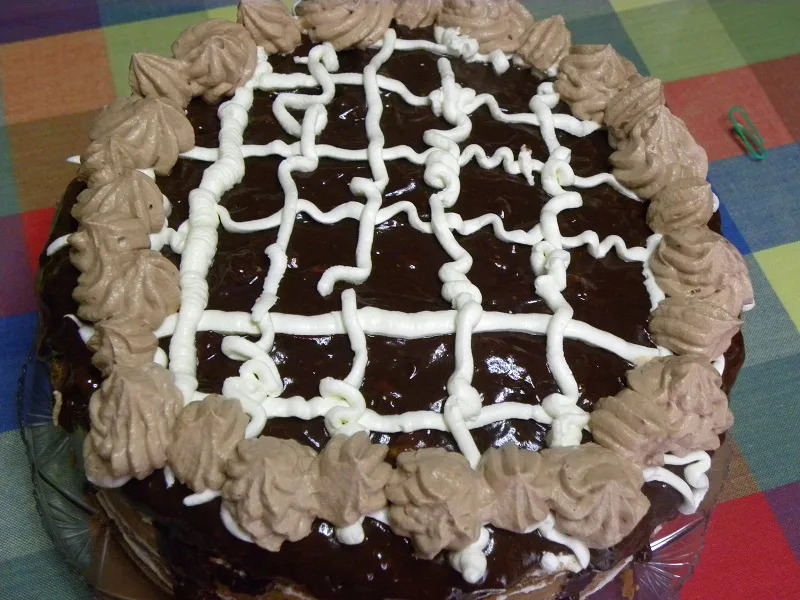 Decorating the cake with dark whipped cream image